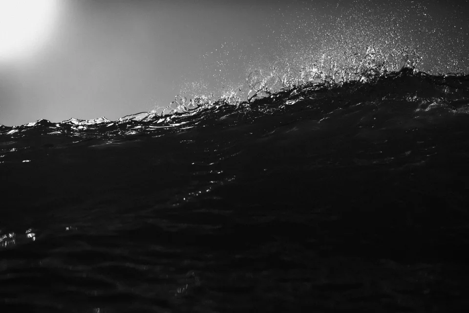 Crête d’une vague noire photographiée au niveau de l’eau