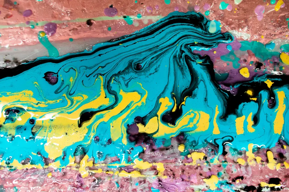 Coulées de résine turquoise, jaune, mauve et noire formant un motif de vague