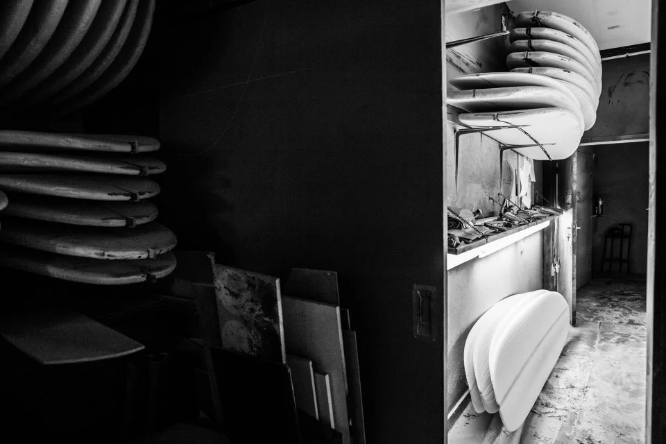 Atelier de shape en noir et blanc avec des planches rangées le long des murs